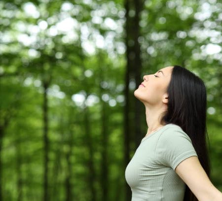 Asian woman breathing fresh air in a forest